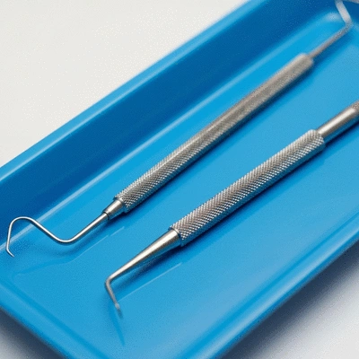Close-up of dental explorer and scaler on a sterile tray
